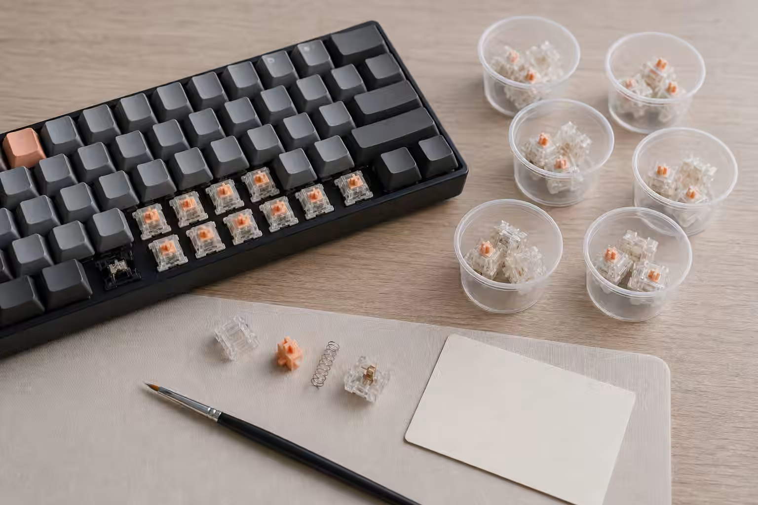 Hot-swap keyboard with switches removed, opened switch parts, and unlabeled switch samples.