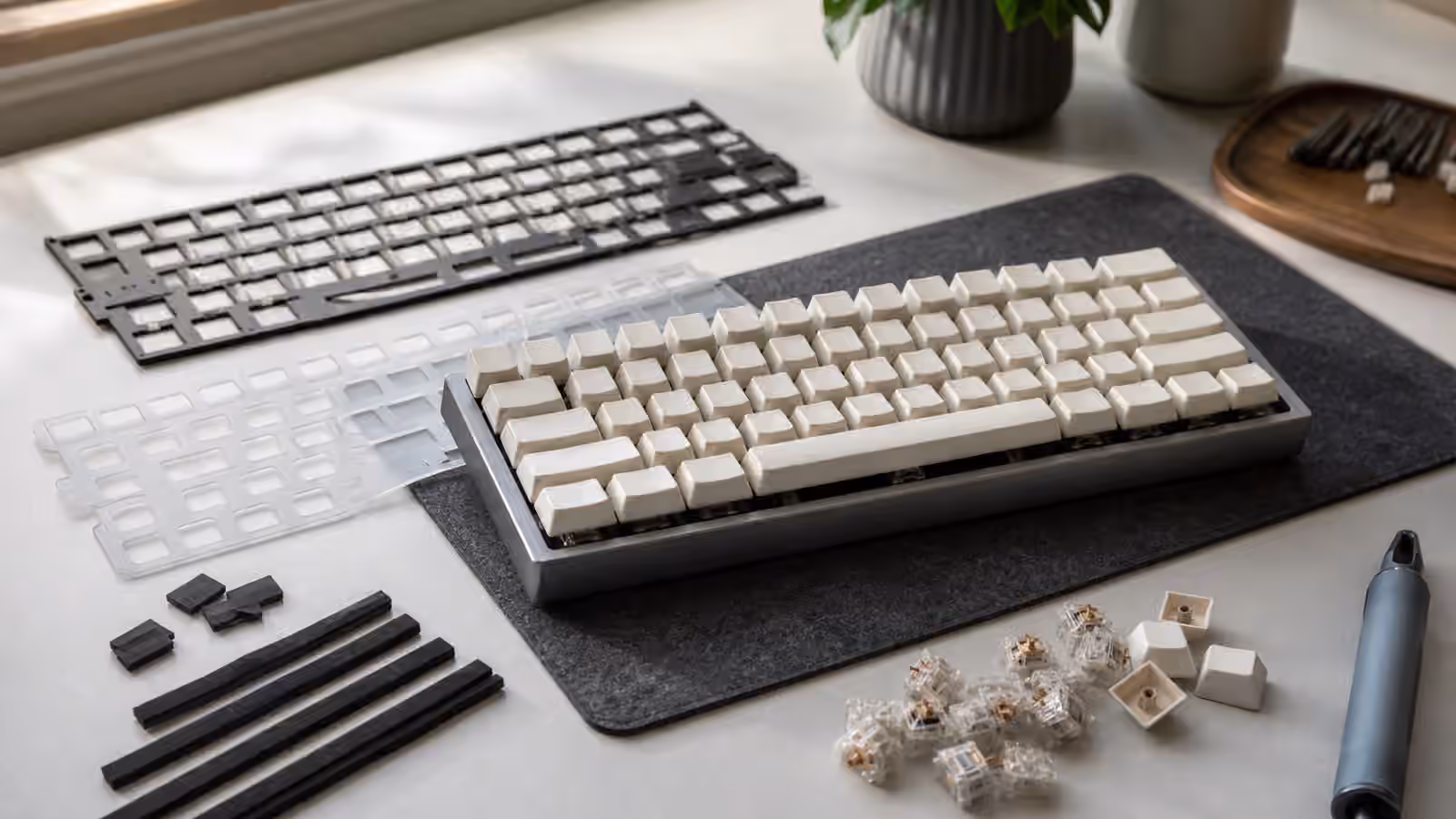 Custom keyboard plate and gasket parts arranged beside a compact mechanical keyboard.