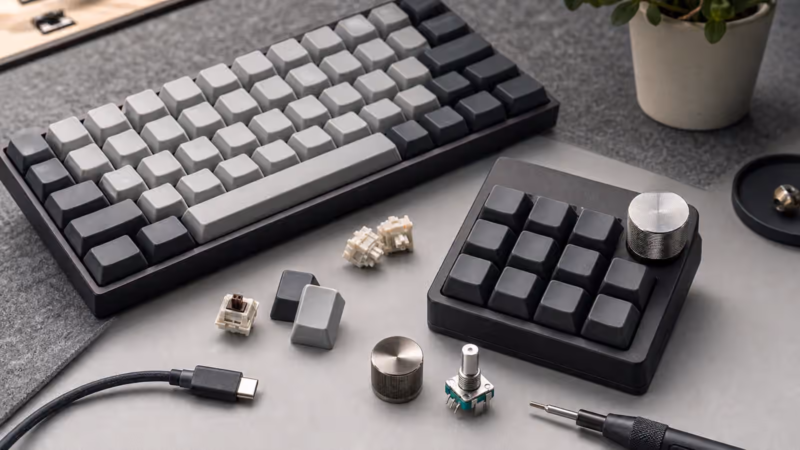 Compact keyboard and macropad with a metal rotary knob and loose switches.
