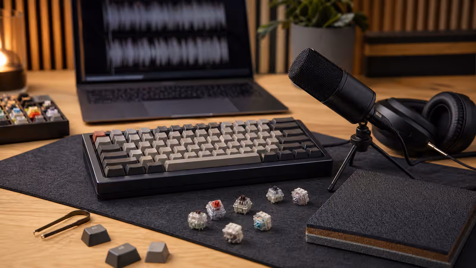 Mechanical keyboard sound comparison setup with microphone, headphones, mat, switches, and keycaps.