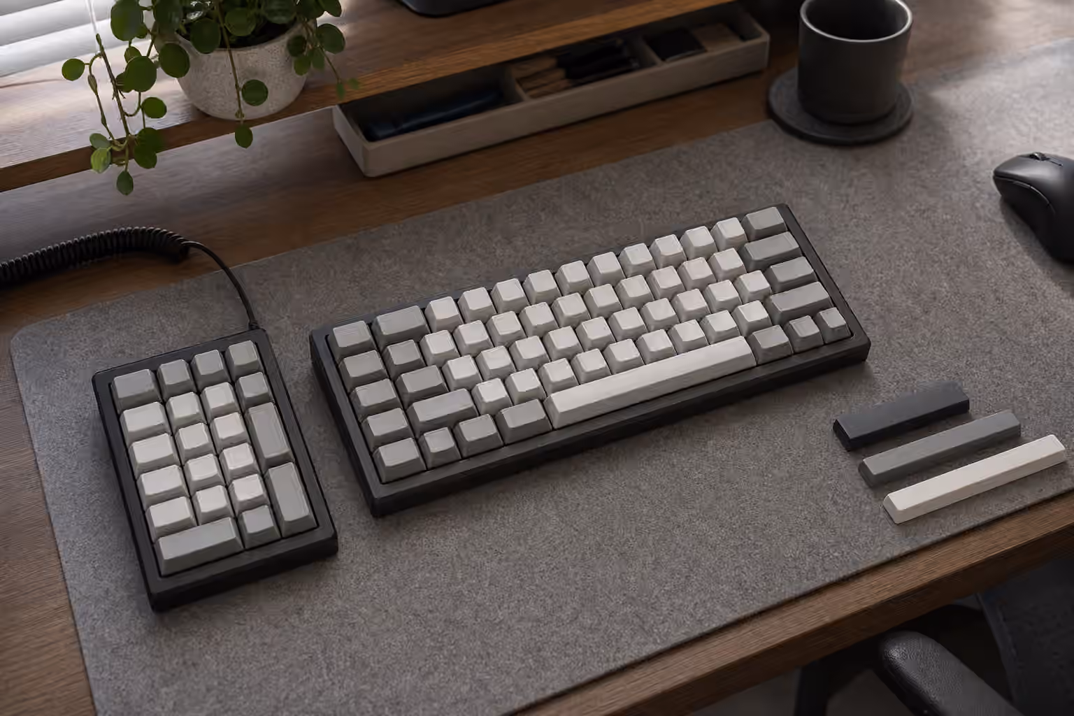 Compact keyboard with a separate left-side numpad on a desk mat and open mouse space on the right.