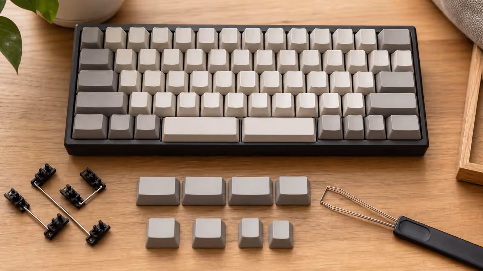 Compact mechanical keyboard with split spacebars, loose thumb keys, stabilizer parts, and a keycap puller on a desk.