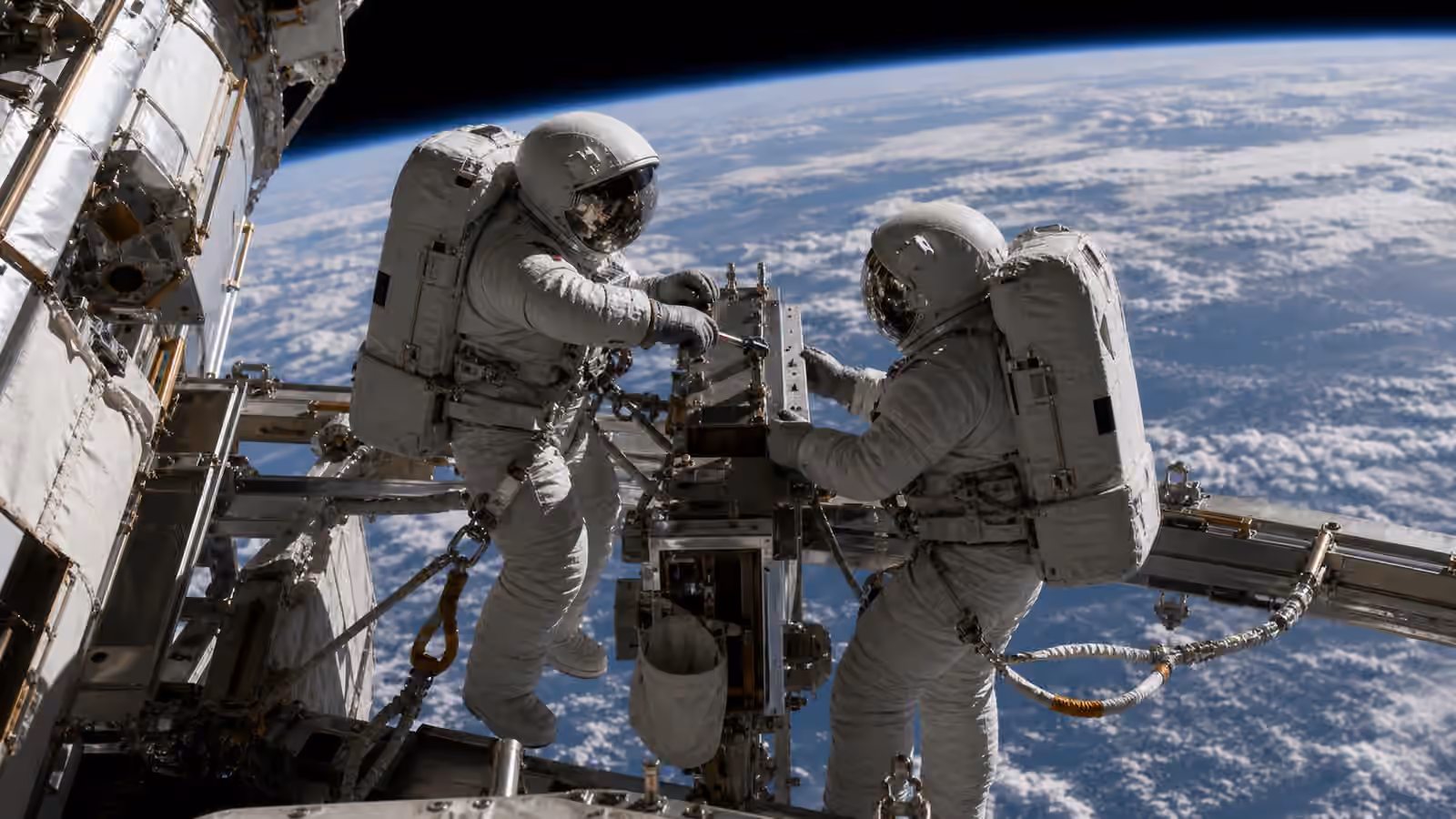 Two astronauts in unbranded EVA suits work on an orbital station structure above Earth.