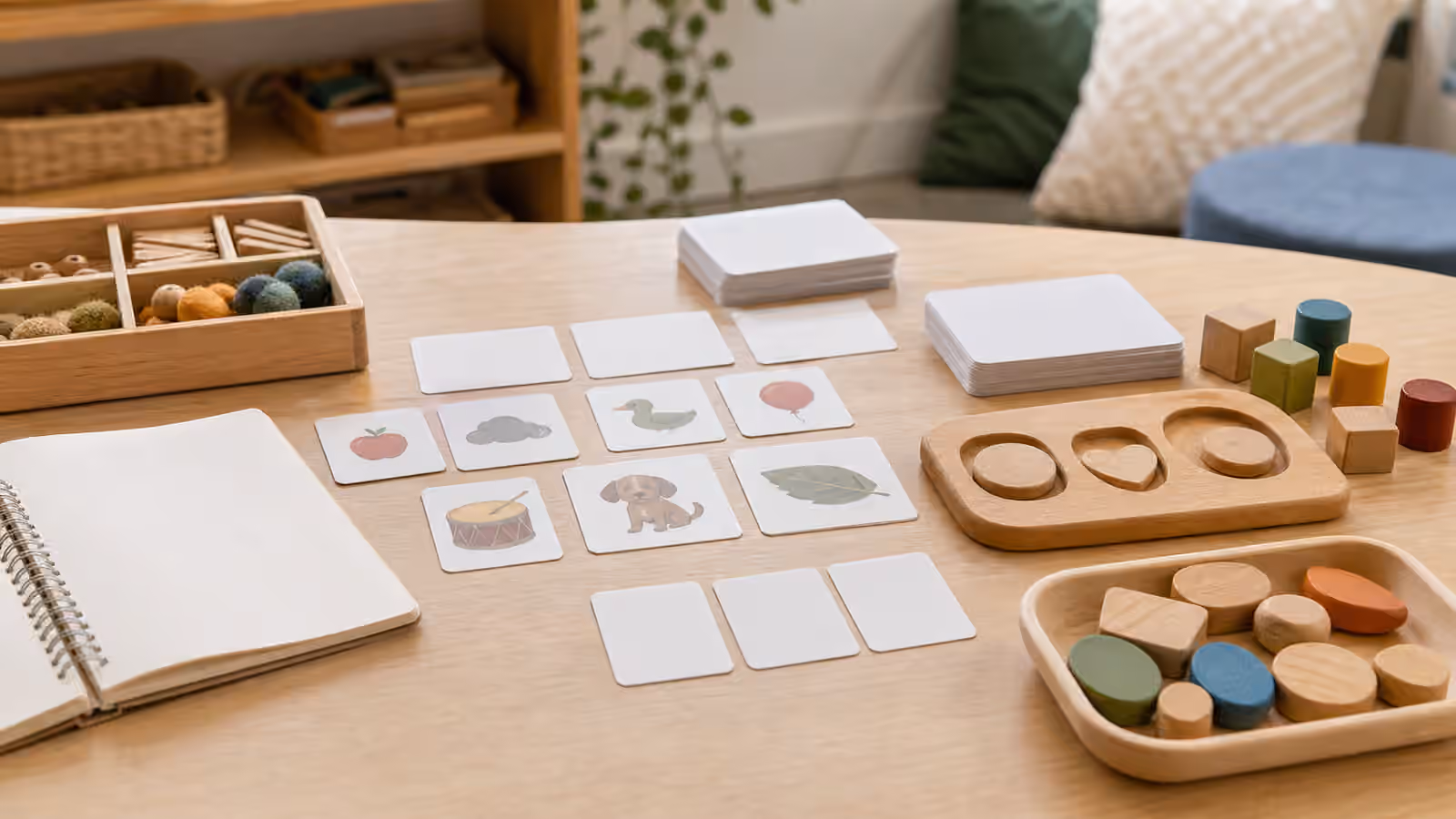 Picture cards, blank cards, blocks, and notebook arranged for speech sound and early literacy practice.